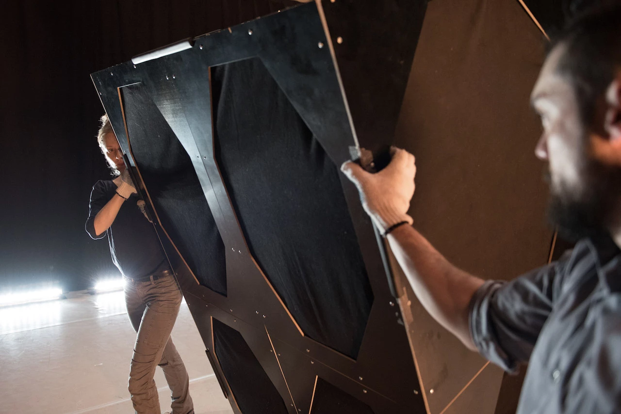 Zwei Personen blicken sich an und halten dabei ein schrankgroßes Musikinstrument (das Gravitaphon)